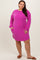 woman wearing a hot pink ribbed long sleeve dress with side pockets and a relaxed fit