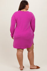 woman wearing a hot pink striped oversized sweater dress with long sleeves and side slits, shown from the back