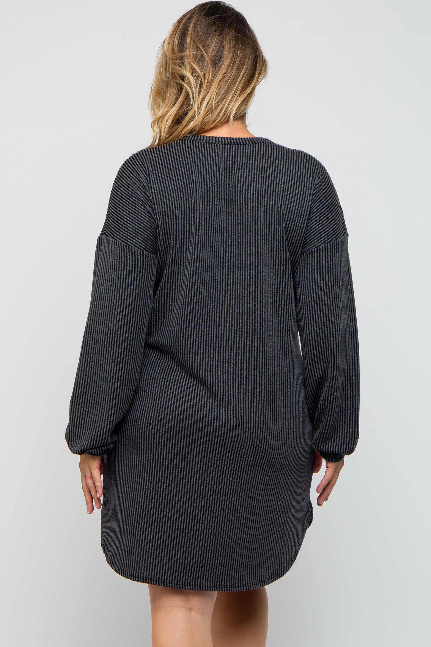 maternity plus woman wearing a black striped long sleeve dress with a relaxed fit and rounded hem