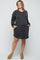 woman wearing a black and white striped long sleeve maternity dress with pockets and a visible baby bump