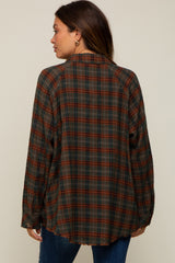 Back view of a woman wearing a brown and green plaid flannel shirt with a raw hem and raglan sleeves