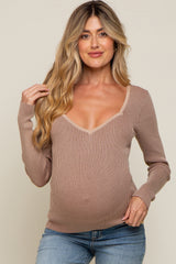 pregnant woman in a tan ribbed long sleeve maternity top with a sweetheart neckline and blue jeans