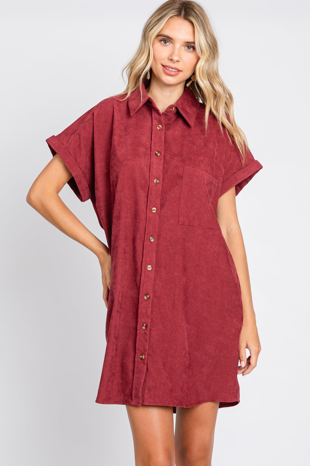woman wearing a burgundy corduroy short sleeve button down shirt dress with a collar and front pocket