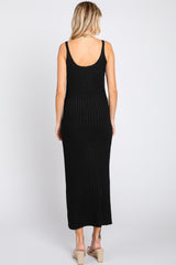 woman wearing a black ribbed maxi dress with a scoop back and a fitted silhouette