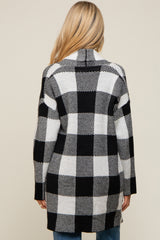 Back view of a woman wearing a long black and white buffalo plaid cardigan sweater