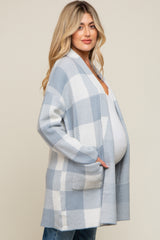 Pregnant woman wearing a light blue and white checkered maternity cardigan over a white top