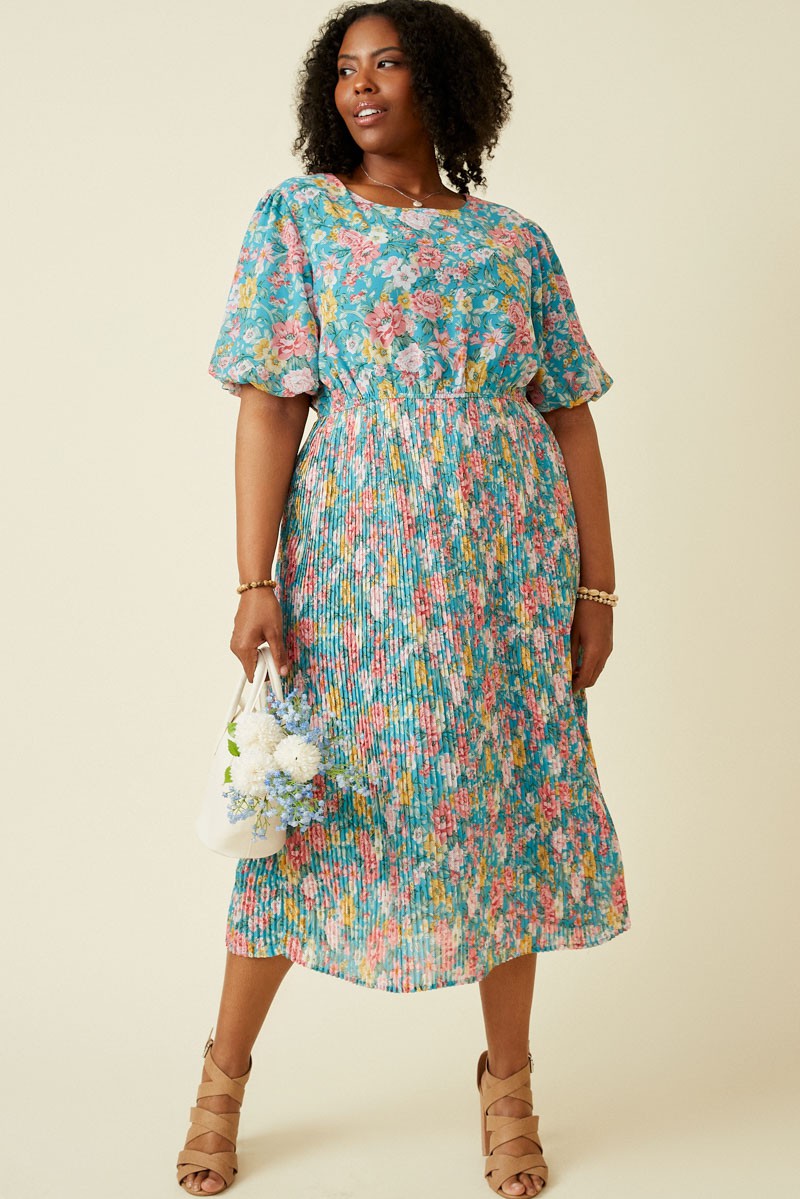 woman wearing a floral plus-size midi dress with short sleeves and a gathered waist, holding a small white bag