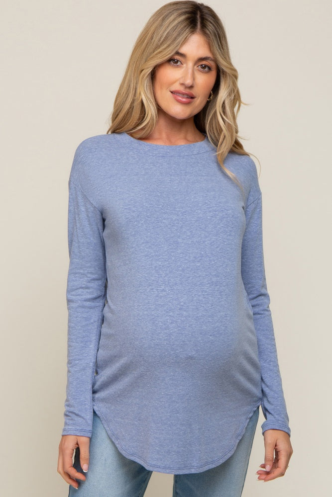 pregnant woman wearing a light blue long sleeve maternity top and jeans