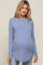 pregnant woman wearing a light blue long sleeve maternity top and jeans