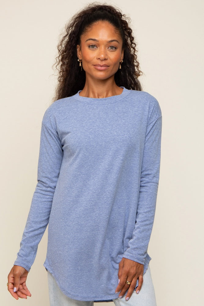 woman wearing a light blue long sleeve crewneck shirt with a curved hem and light wash jeans