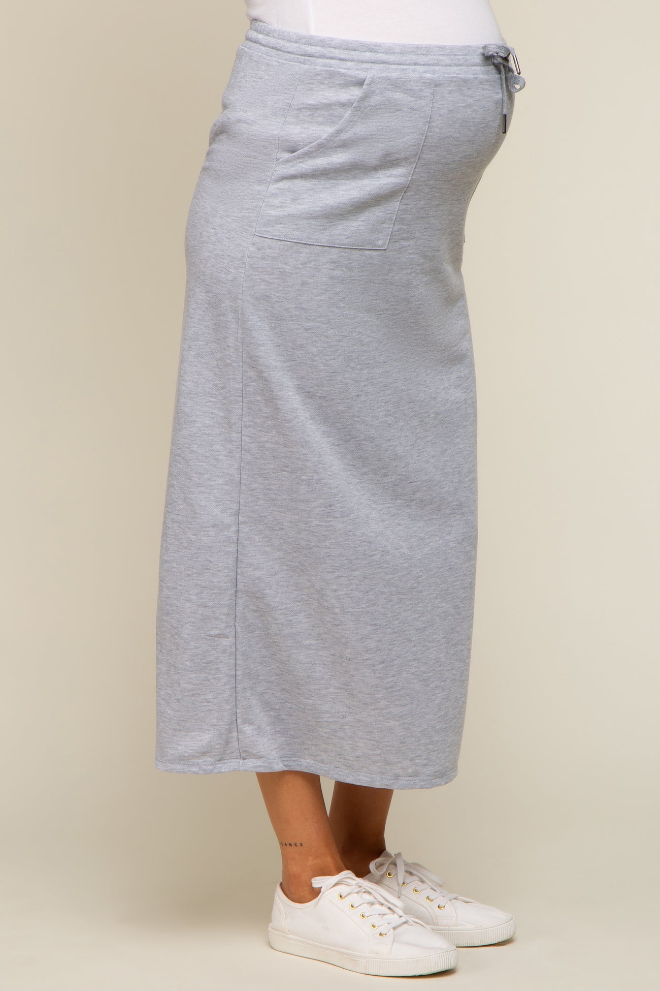 woman wearing a grey maternity maxi skirt with a drawstring waist and visible baby bump
