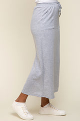 woman wearing a grey midi skirt with pockets and drawstring waist, paired with white sneakers