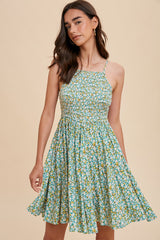 woman wearing a green floral sundress with a smocked bodice and a flared skirt
