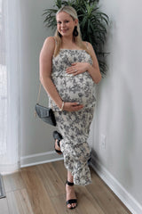 woman wearing a floral print maternity maxi dress and holding her baby bump