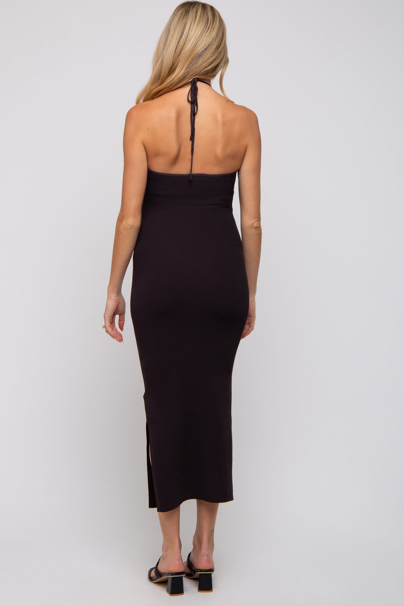 woman wearing a dark purple ribbed maternity dress with a halter neck and side slits