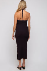 woman wearing a dark purple ribbed maternity dress with a halter neck and side slits
