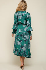 woman wearing a green floral print maternity dress with bell sleeves and a ruffled hem, shown from the back
