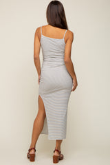 woman wearing a striped maternity maxi dress with side slit and adjustable straps, showing a baby bump