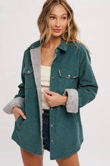 woman wearing a teal corduroy jacket with grey faux fur lining, button closures, and side pockets, styled with a tank top and shorts