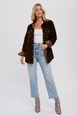 woman wearing brown corduroy jacket with faux fur lining, light wash jeans, and snakeskin boots