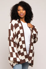 woman wearing a brown and cream checkered oversized cardigan over a white top and light blue jeans