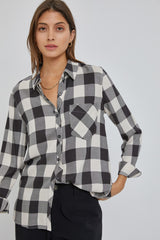 woman wearing a black and white buffalo plaid button-down shirt with gold jewelry