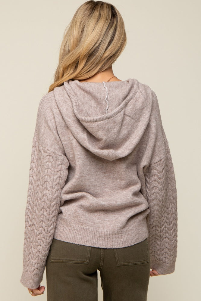 maternity wear back view of a light beige hoodie with cable knit sleeves and a relaxed fit