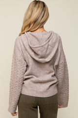 maternity wear back view of a light beige hoodie with cable knit sleeves and a relaxed fit