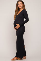 woman wearing a black long sleeve maternity dress with side slits and a visible baby bump