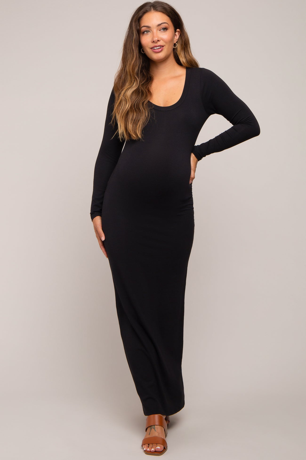 woman wearing a black long sleeve maternity maxi dress and showing her baby bump