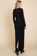 woman wearing a black long sleeve maxi dress with a back slit and fitted silhouette