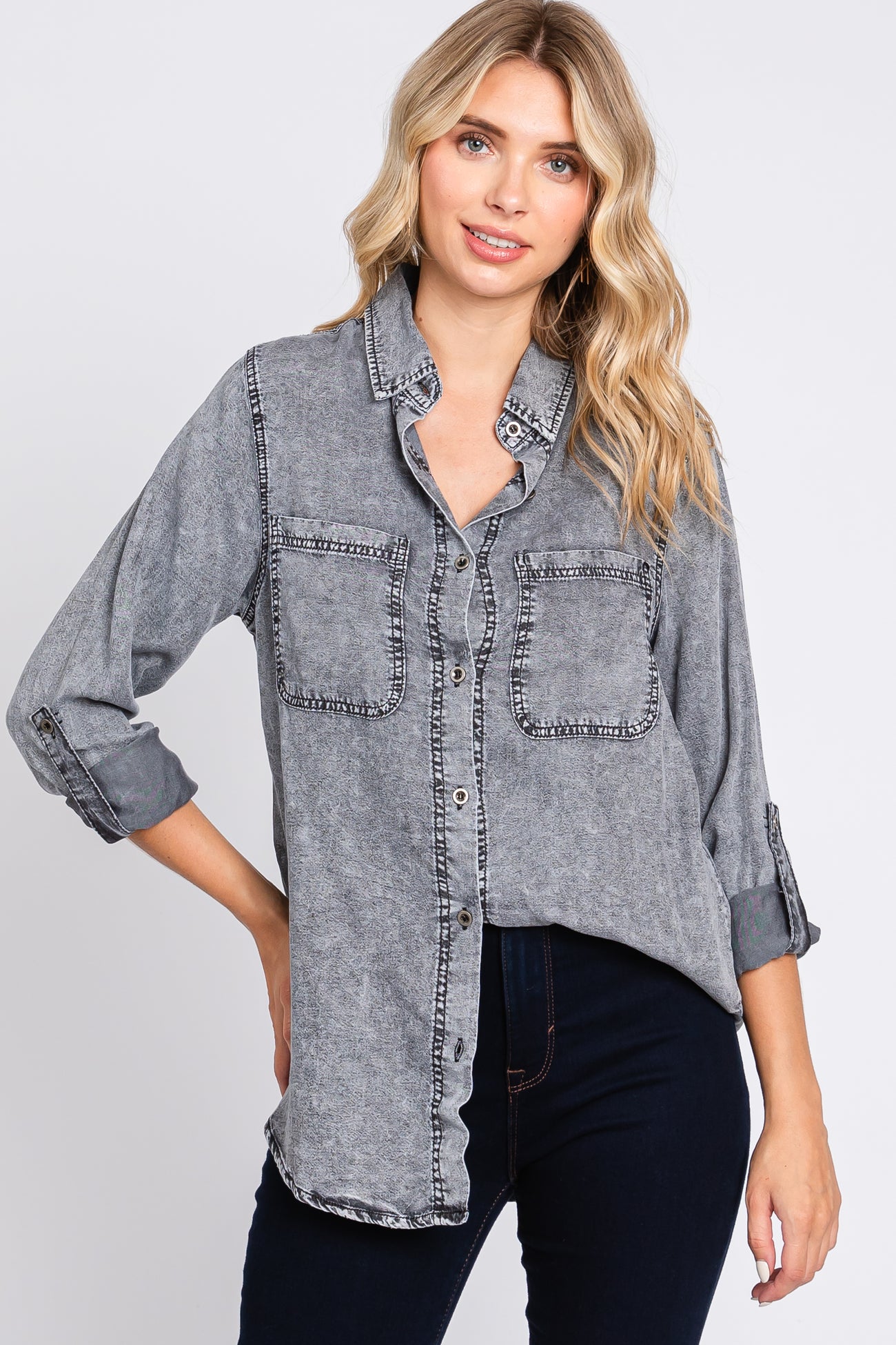 woman wearing a gray button-up shirt with two chest pockets and rolled sleeves