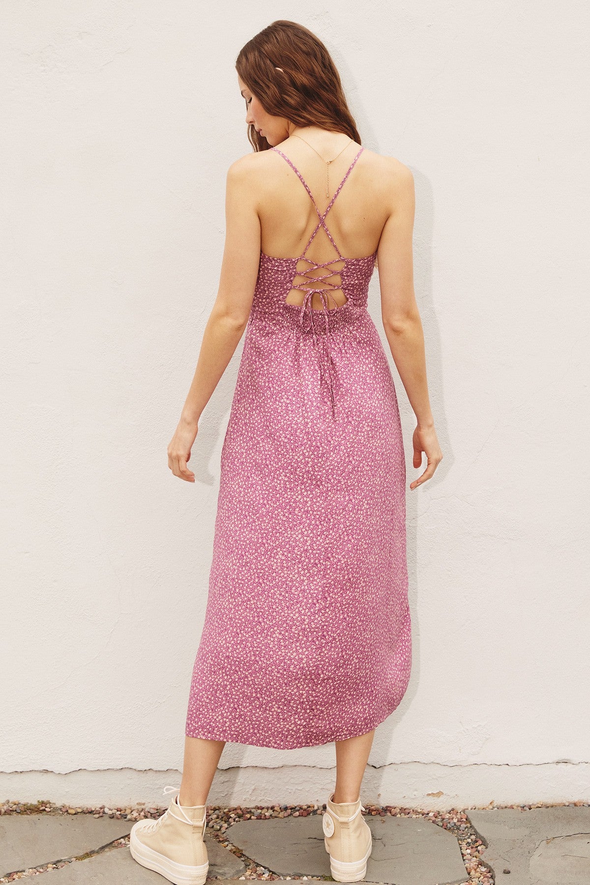 woman wearing a pink floral maxi dress with crisscross back straps