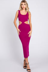 woman wearing a fuchsia midi dress with cut-out details and a fitted silhouette, styled with black strappy heels