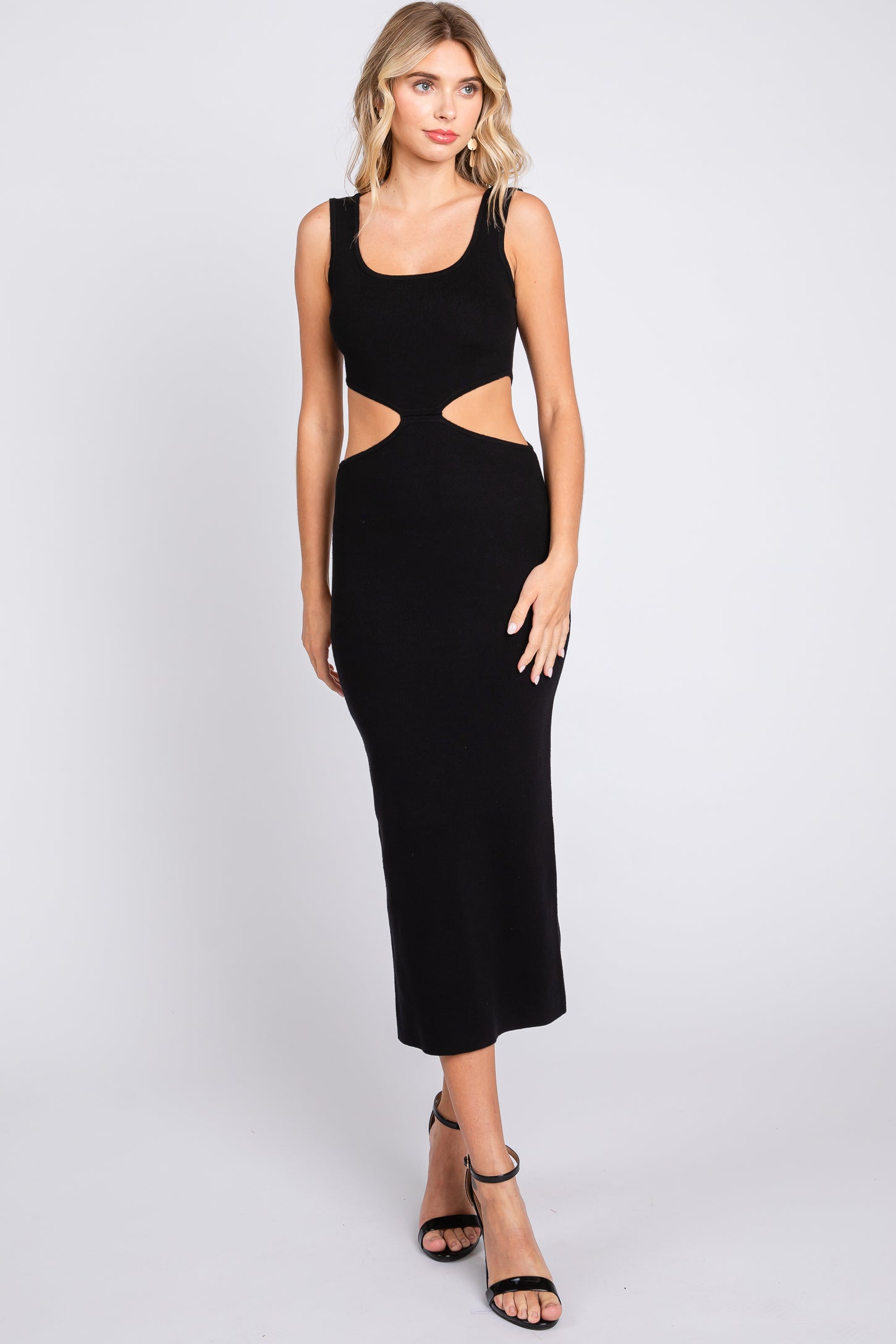 woman wearing a black cut-out midi dress with a fitted silhouette and tank straps
