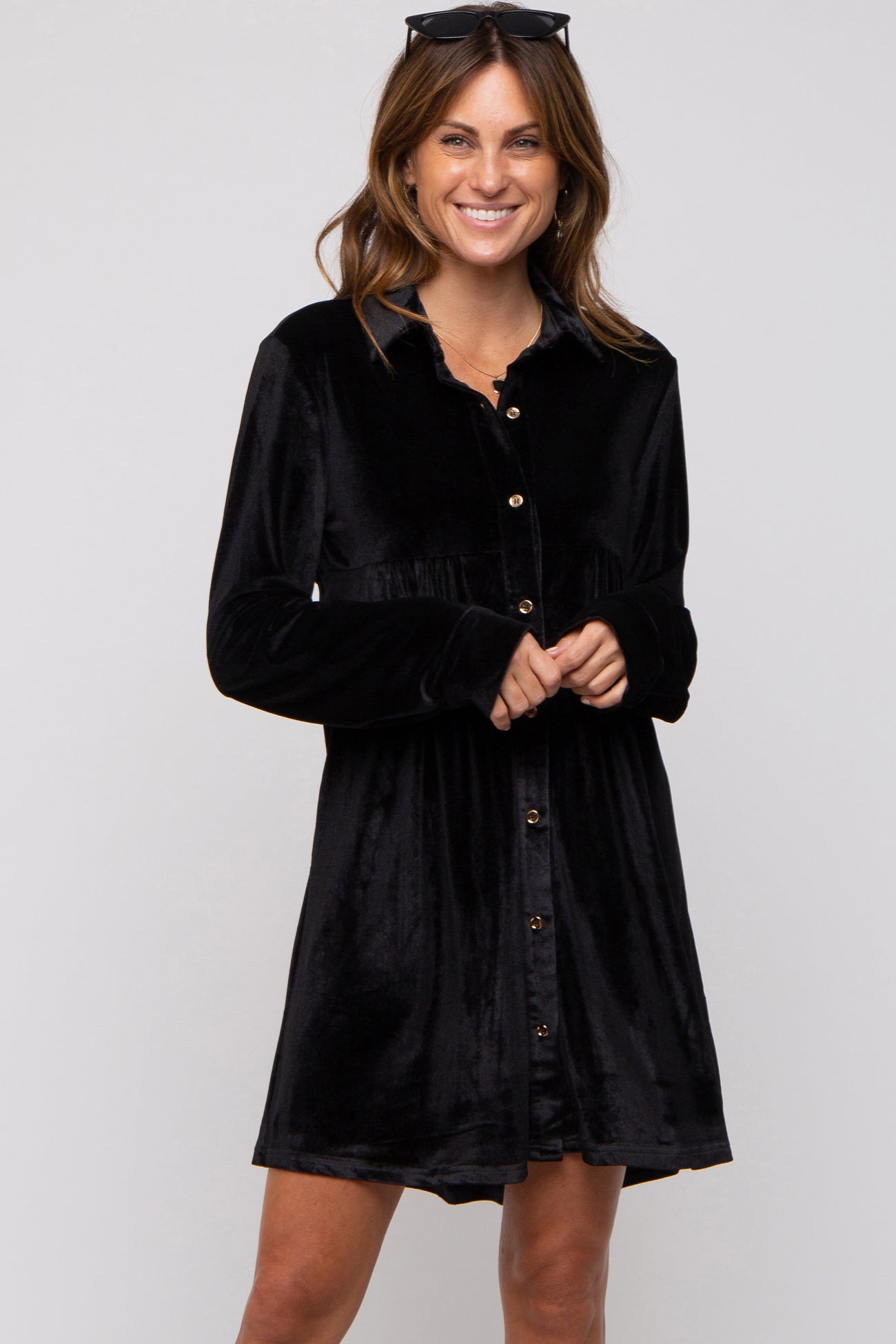woman wearing a black velvet long-sleeve button-up dress with a relaxed fit and full skirt