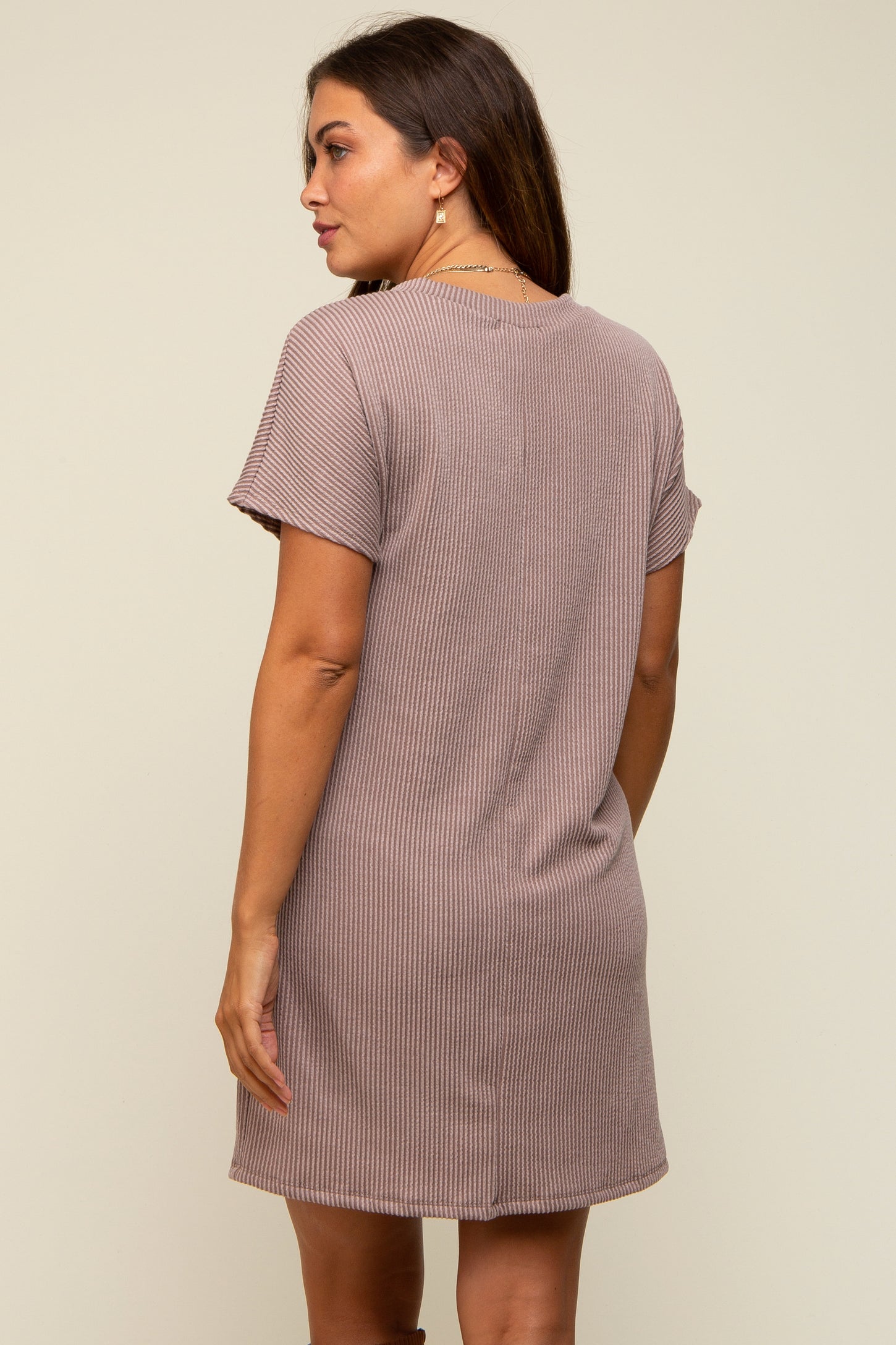 woman wearing a taupe short sleeve maternity dress with a relaxed fit and ribbed texture, showing the back view