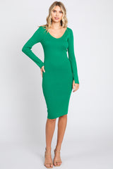 woman wearing a fitted green ribbed long sleeve dress with a scoop neckline and mid-length hem