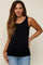 woman wearing a black maternity tank top with a fitted design and side ruching, smiling at the camera