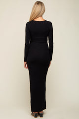 woman wearing a black long sleeve maternity maxi dress, back view with a fitted silhouette