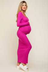 woman wearing a hot pink long sleeve maternity dress with a visible baby bump