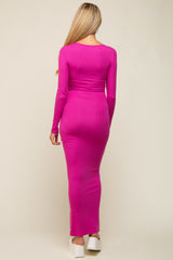 woman wearing a form-fitting fuchsia long sleeve maternity dress, showing a visible baby bump from the back