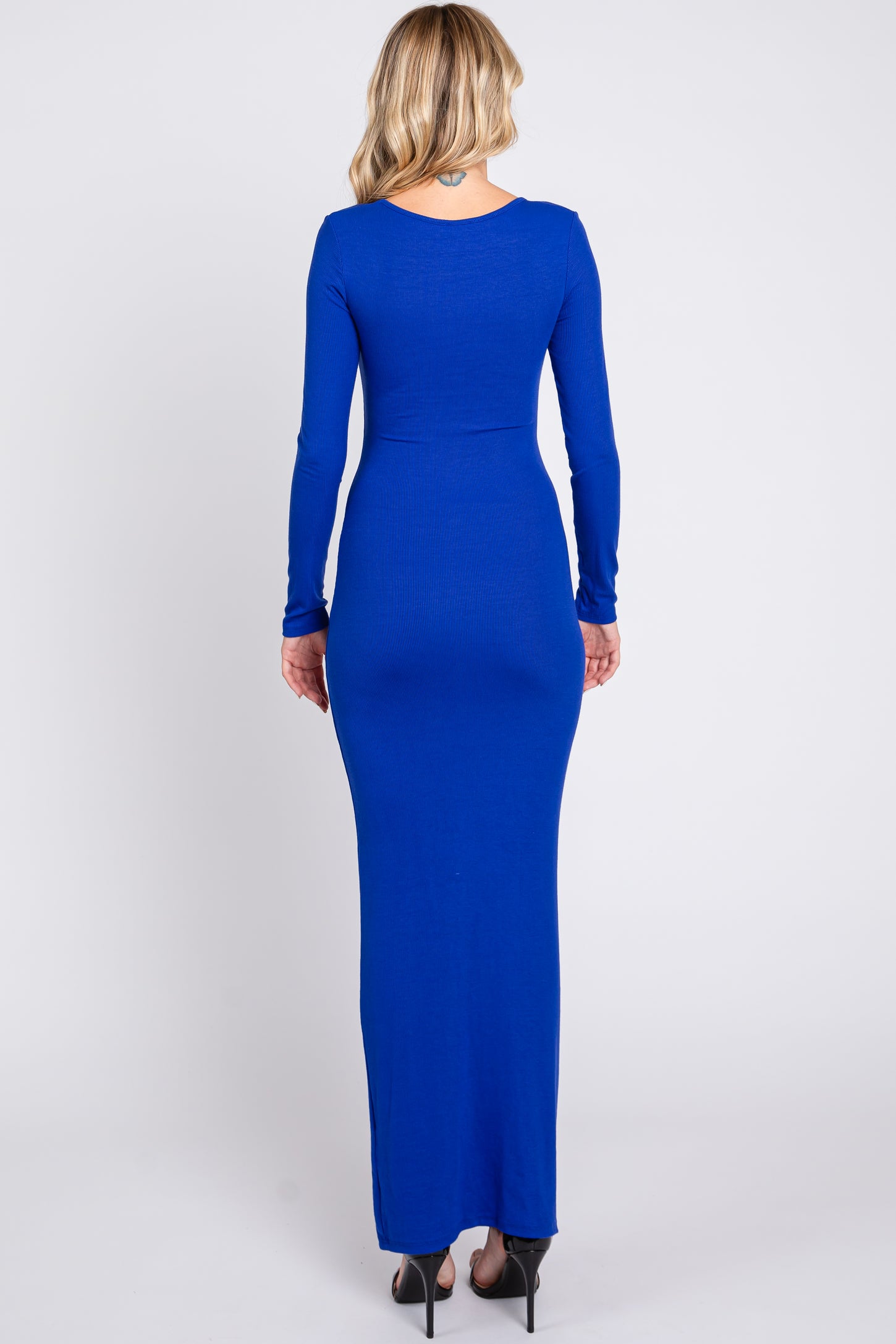 woman wearing a fitted long sleeve royal blue maxi dress showing the back view and revealing a sleek silhouette