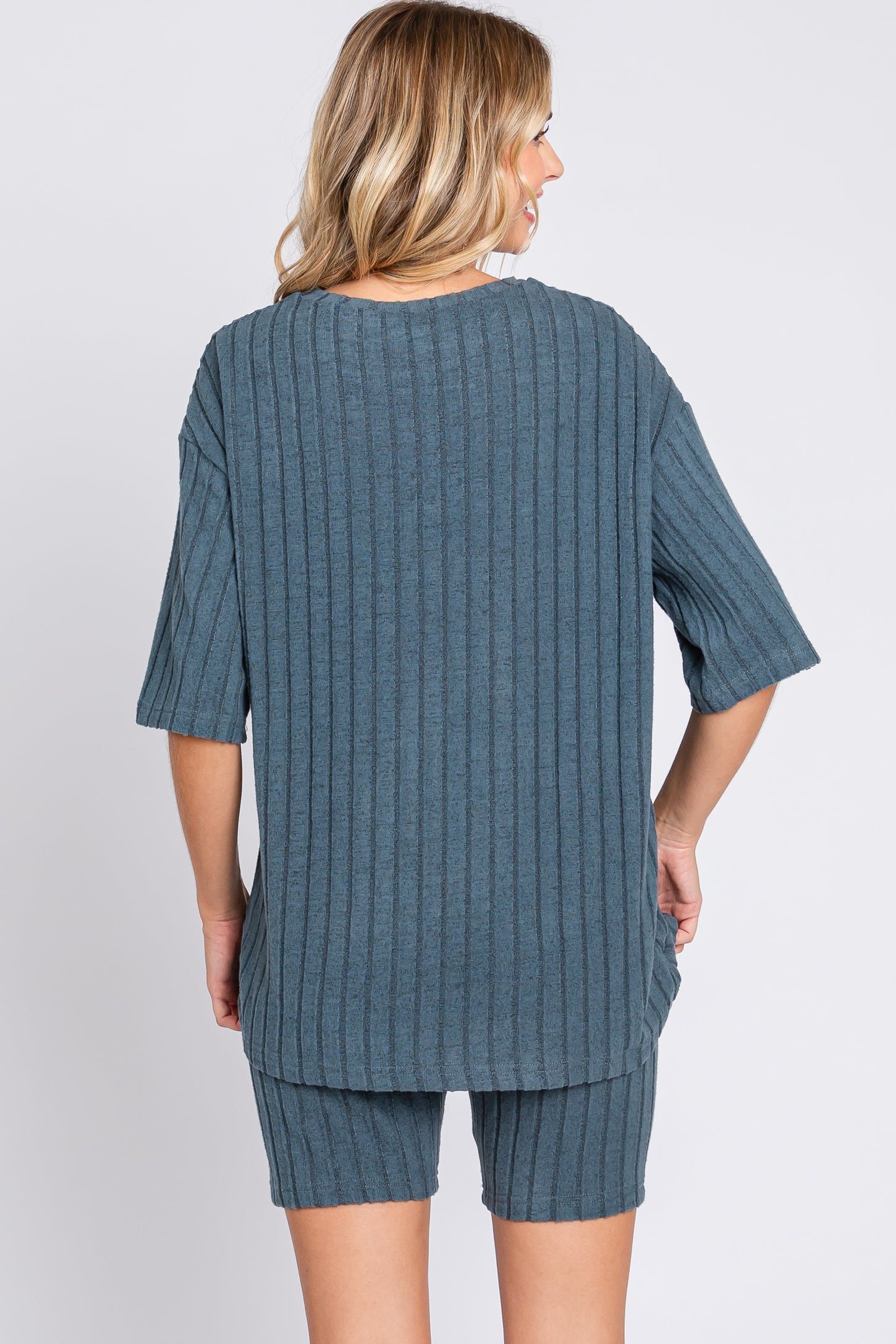 woman wearing a slate blue ribbed short sleeve top and matching shorts from the back