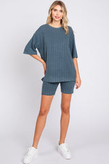 woman wearing a teal ribbed knit oversized top and matching shorts with white sneakers