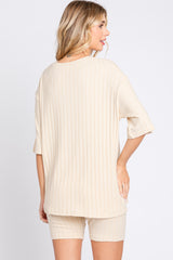 woman wearing a beige ribbed two-piece set with a loose short-sleeve top and matching shorts, view from the back