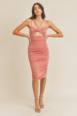 woman wearing a coral ruched bodycon dress with a cut-out detail and crisscross straps