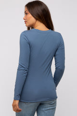 woman wearing a dark blue long sleeve maternity top, showing the back view and styled with jeans