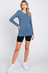 woman wearing a long sleeve blue top paired with black bike shorts and white sneakers