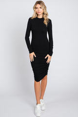 woman wearing a black long sleeve ribbed midi dress with gathered detailing and white sneakers